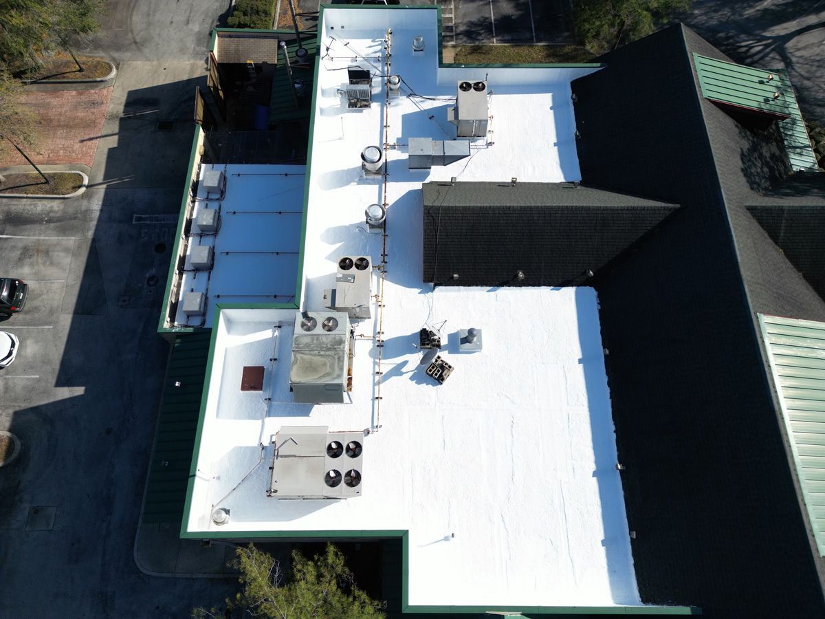 An aerial view of a large building with a white roof.
