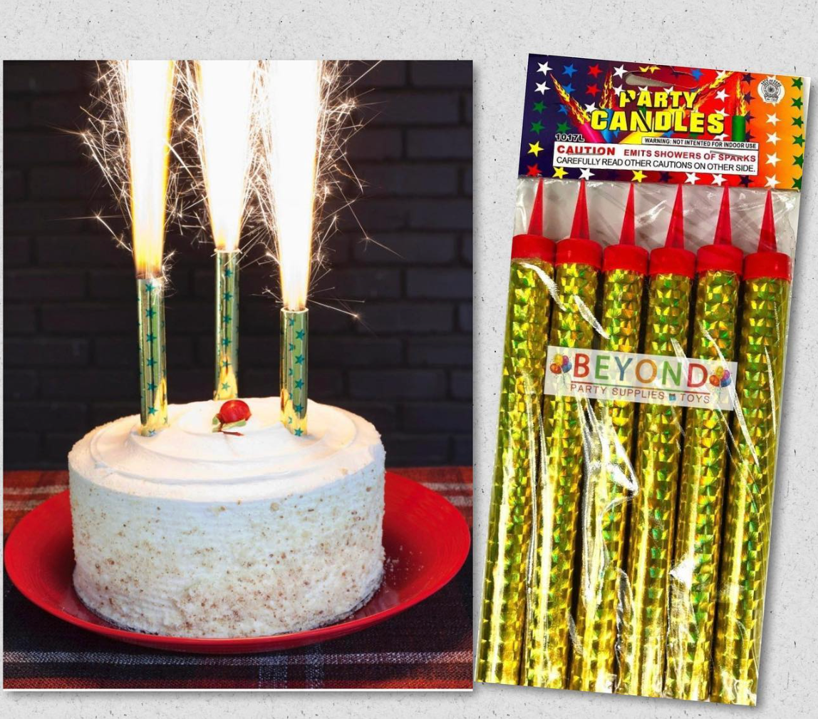 Birthday cake with lit sparkler candles beside a package of gold sparkler candles