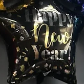 Black star balloon with gold “Happy New Year” lettering and confetti accents