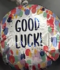 Colorful balloon-patterned sign with “GOOD LUCK!” in bold black letters