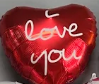 Red heart-shaped balloon with white “love you” text on it