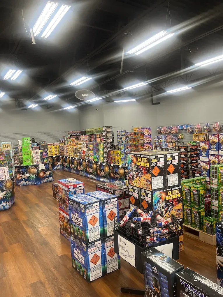 Grocery store aisle with colorful snack displays under bright ceiling lights.