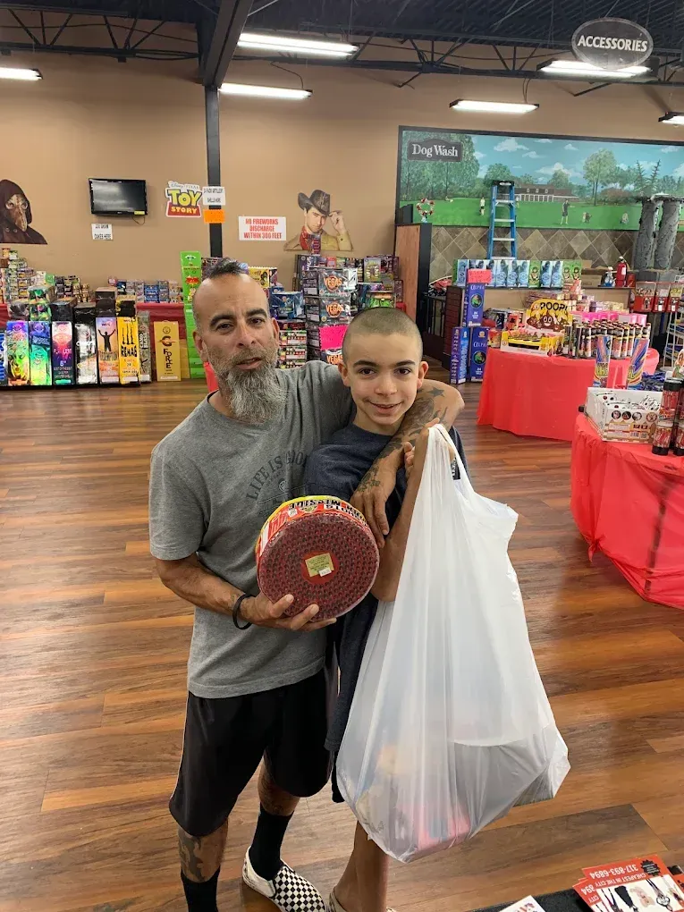 Two people in a store holding a round item and a white shopping bag, with shelves and displays behind them.