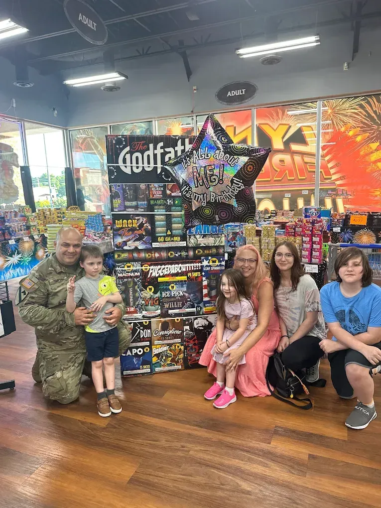 Children posing in a store aisle beside a colorful candy display and wall mural