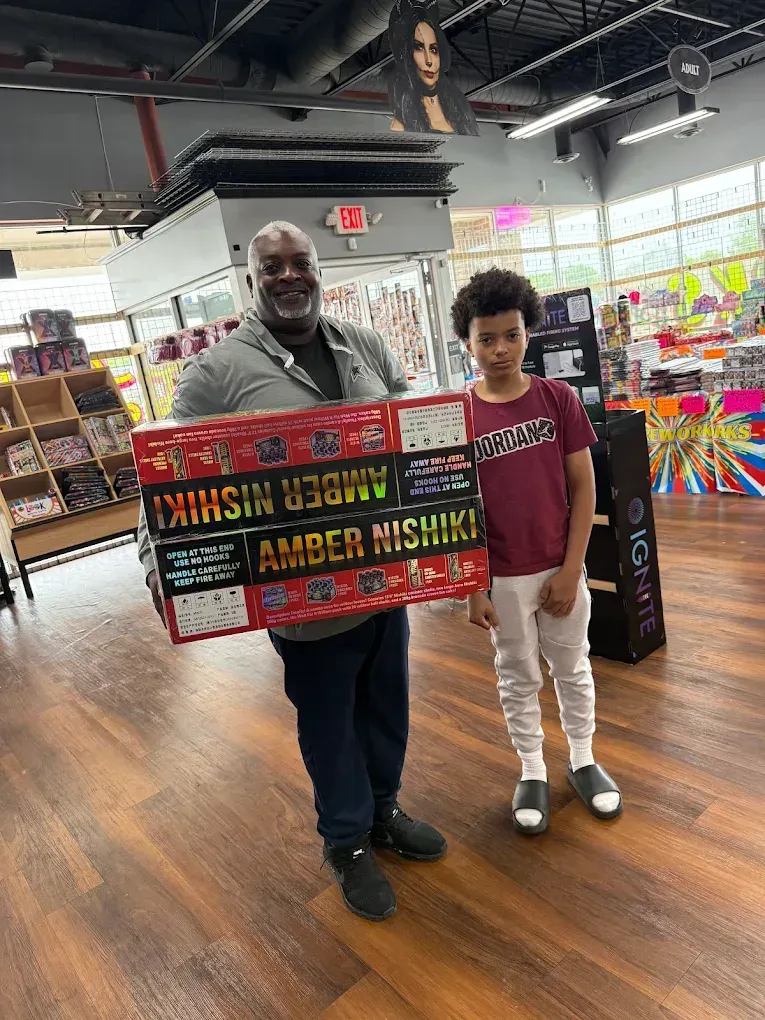 Two people holding a colorful custom sign in a bright indoor venue.