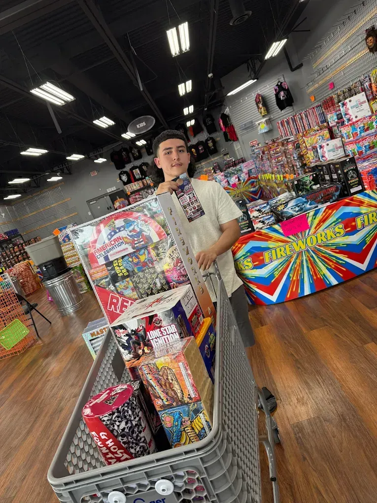 Person holding a cart of colorful puzzles in a store aisle with wood floors and bright overhead lights