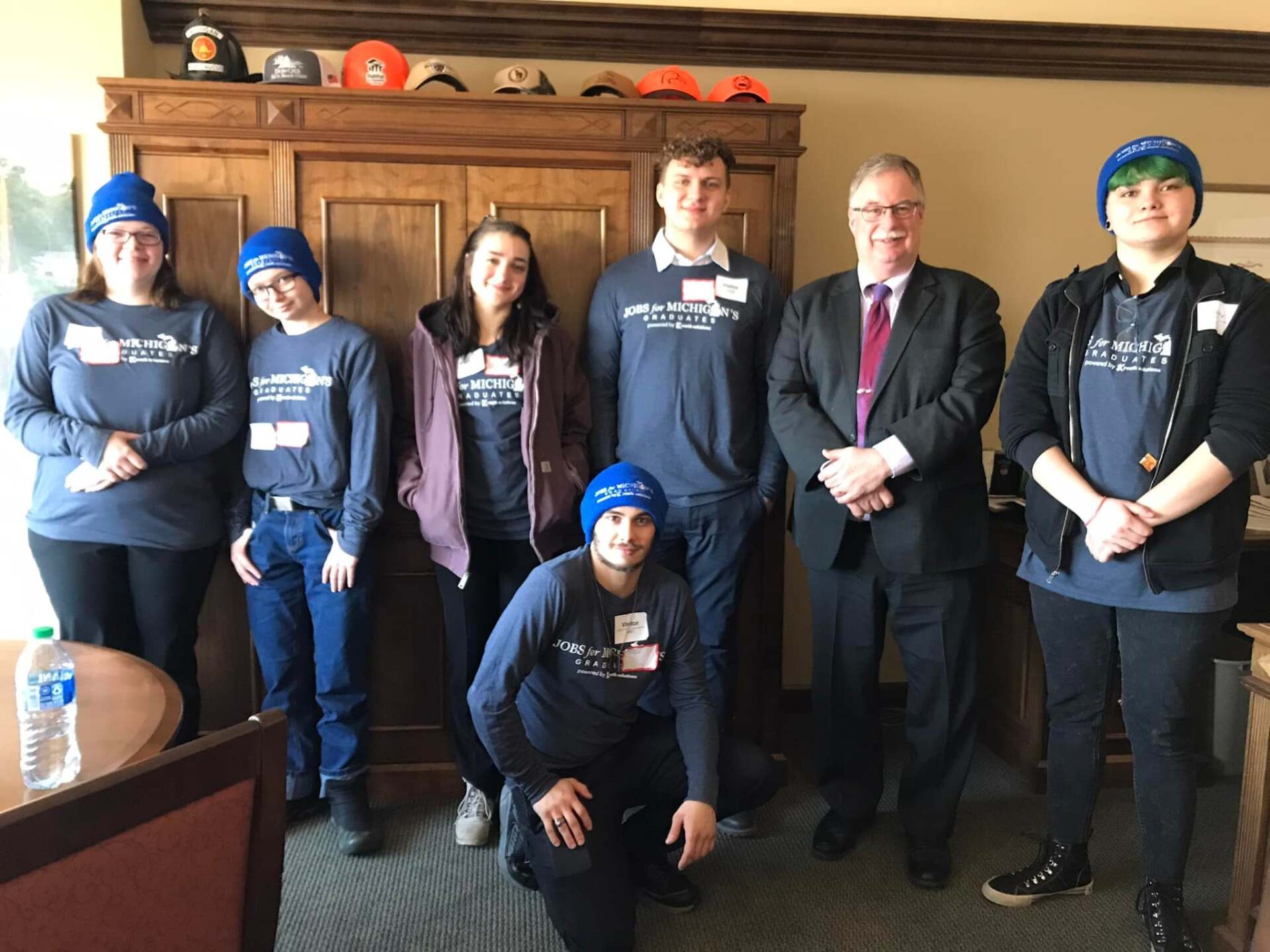 A group of people are posing for a picture in a room.