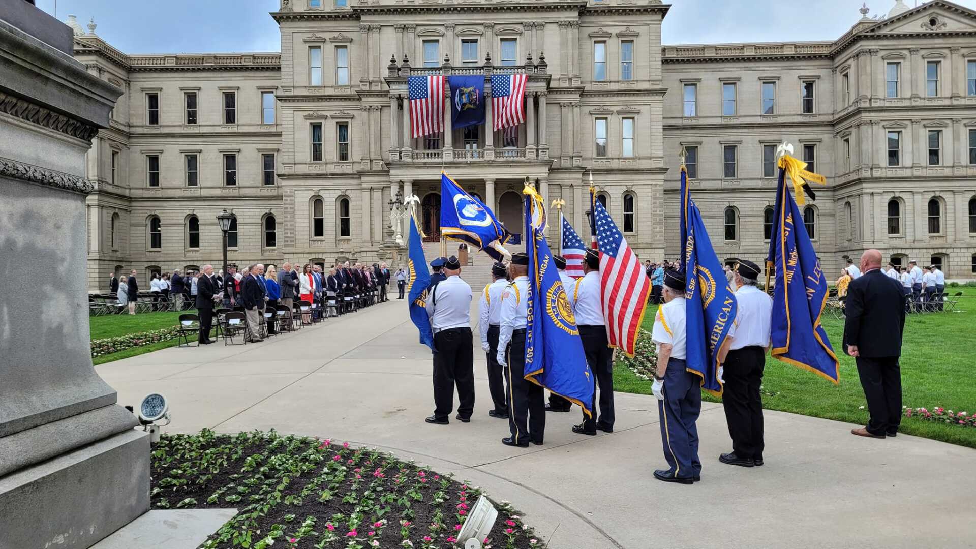A group of people holding flags in front of a large building.