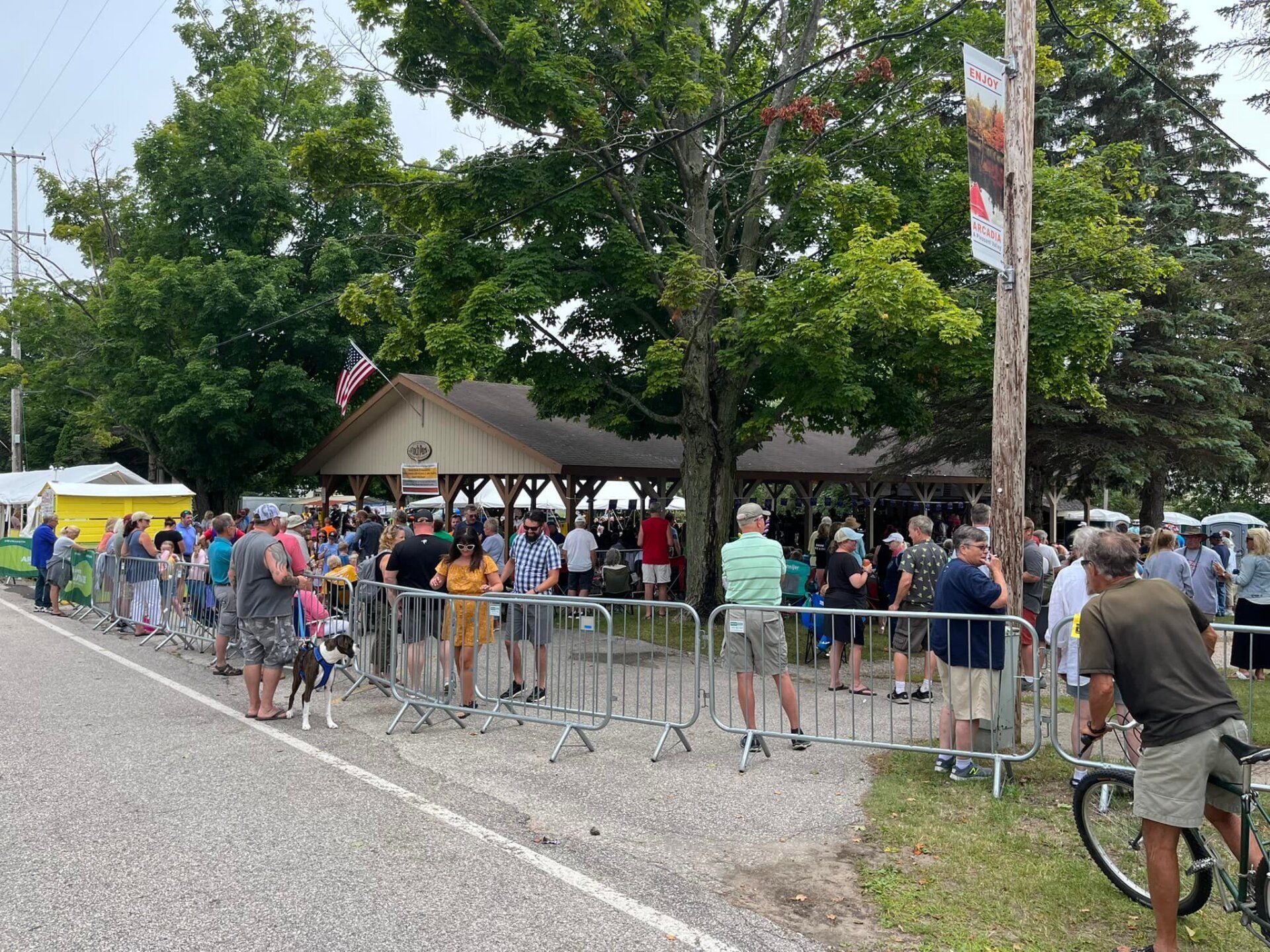 A group of people are standing in a line behind a fence.