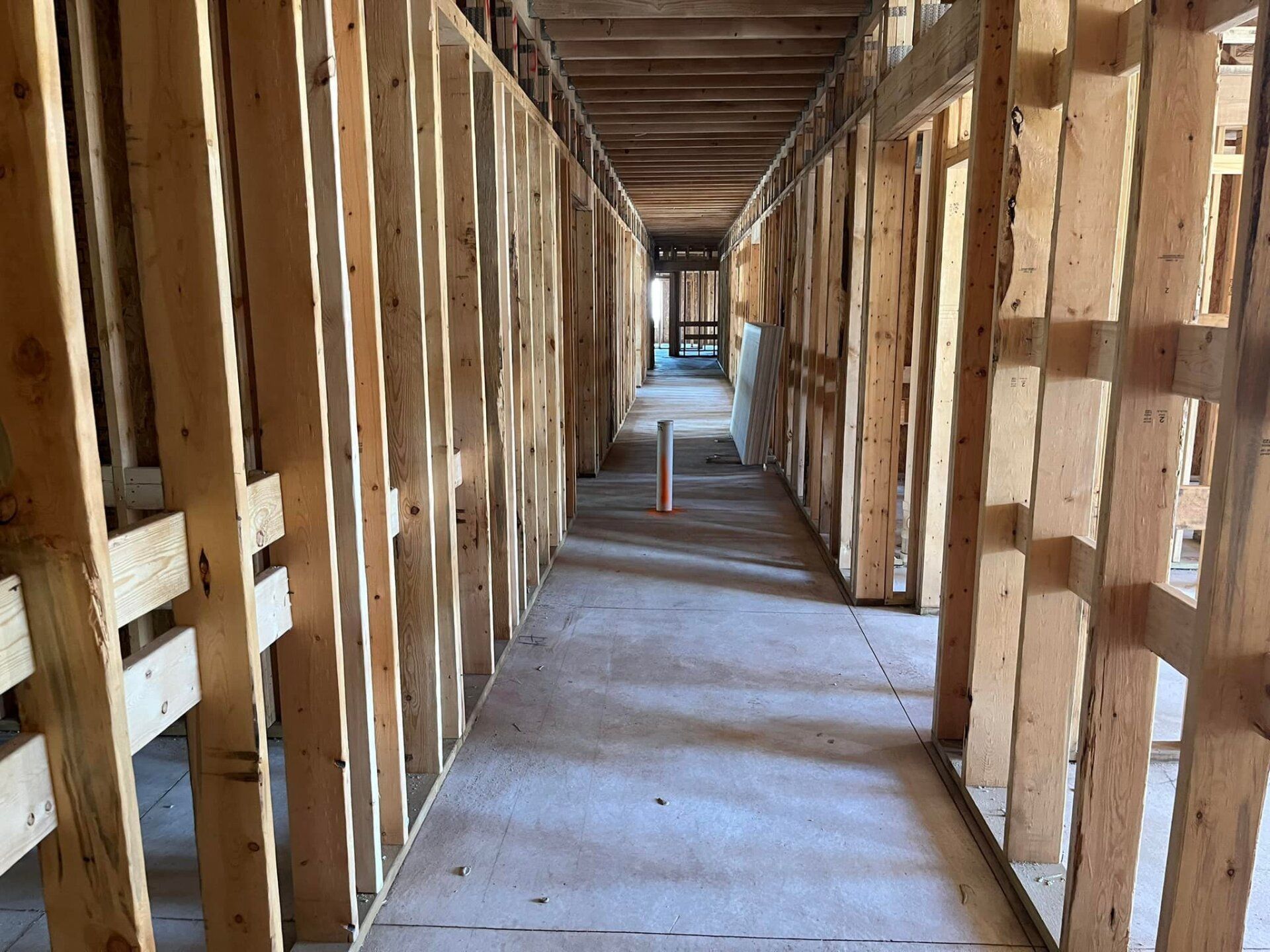A long hallway with wooden walls under construction.