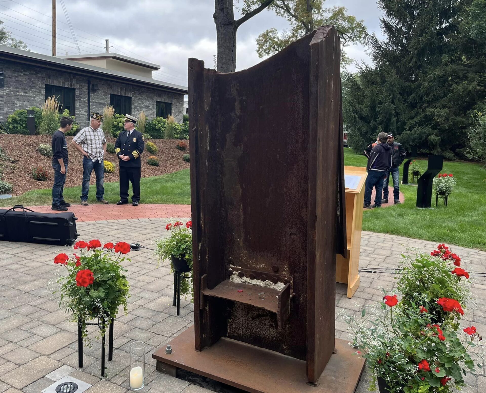 A group of men are standing around a large metal sculpture.