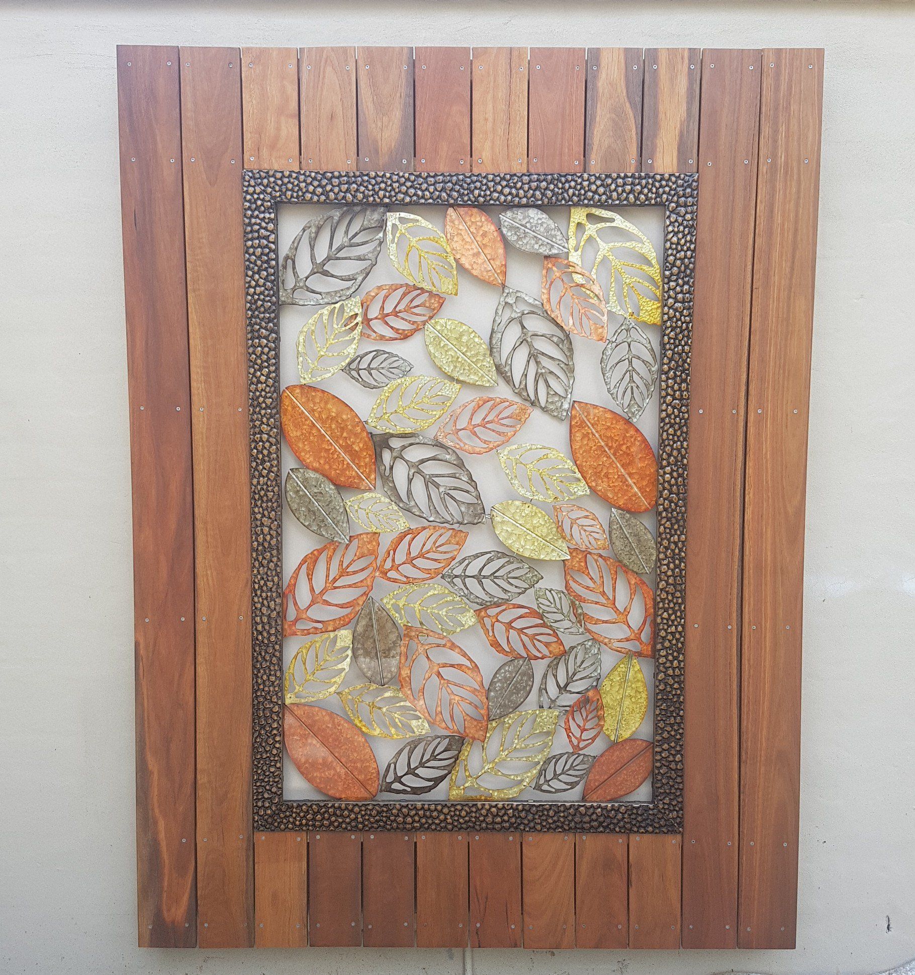 Wooden framed wall art with fall-colored leaf design.