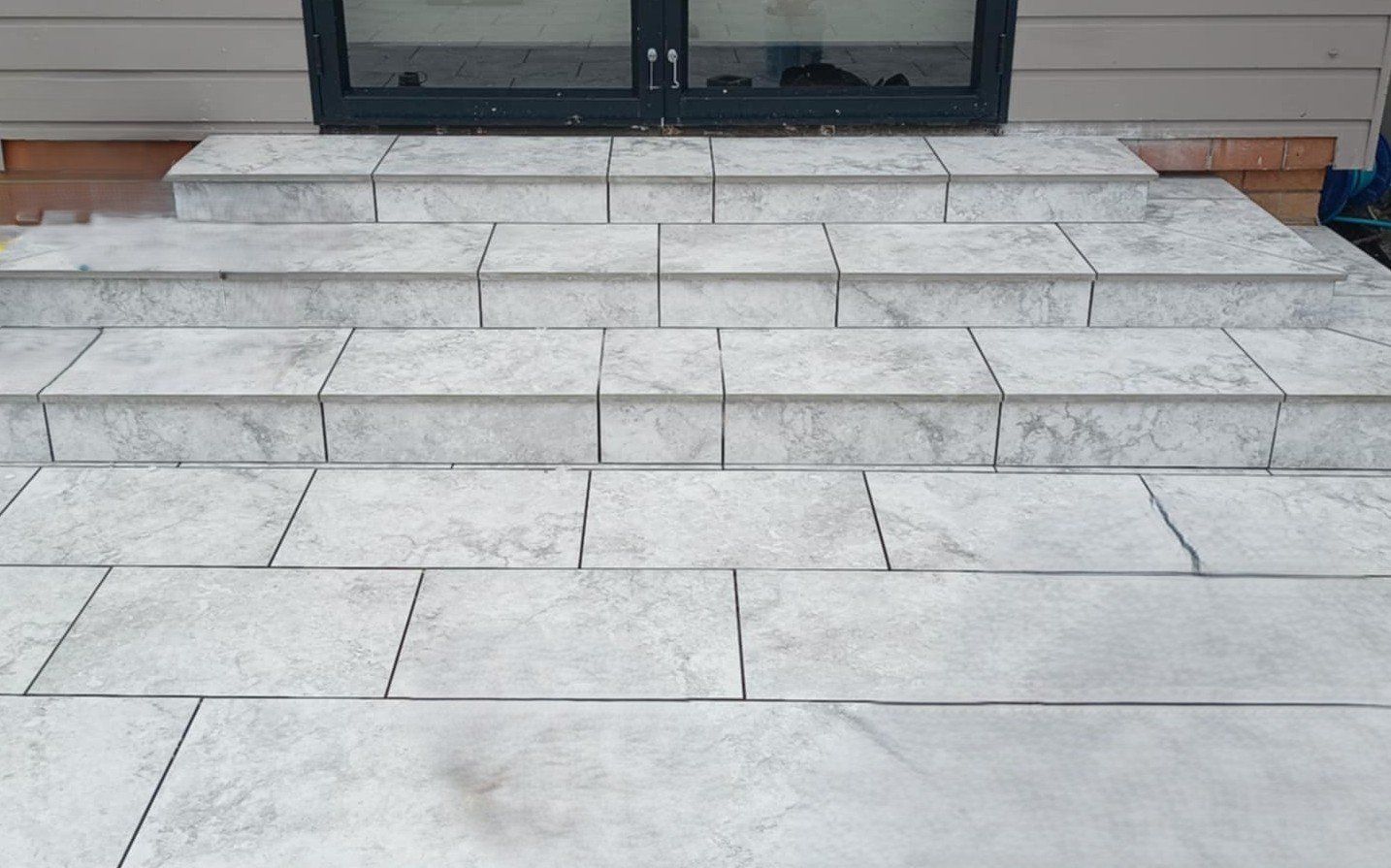 Gray tiled steps leading up to a doorway.