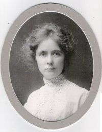 Young woman in white dress, posed portrait in oval frame.