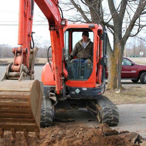 Man on excavator — Allegan, MI — Tim Rogers Plumbing LLC