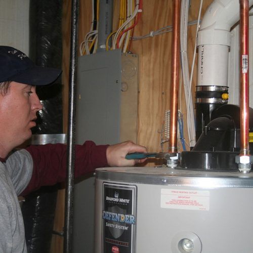 Man checking on water heater — Allegan, MI — Tim Rogers Plumbing LLC