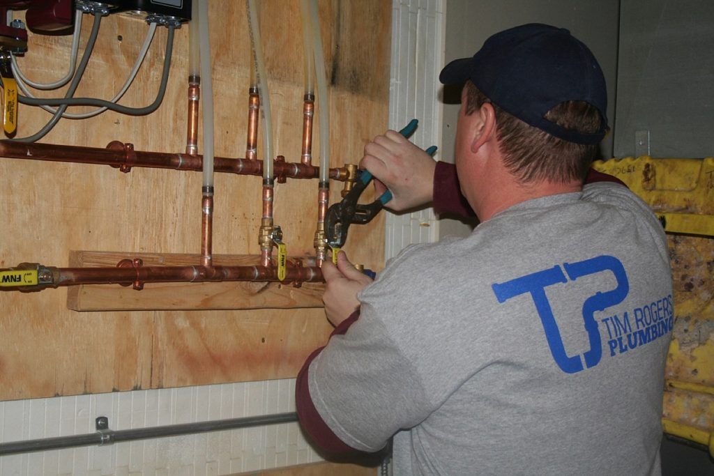 Worker working on pipes — Allegan, MI — Tim Rogers Plumbing LLC