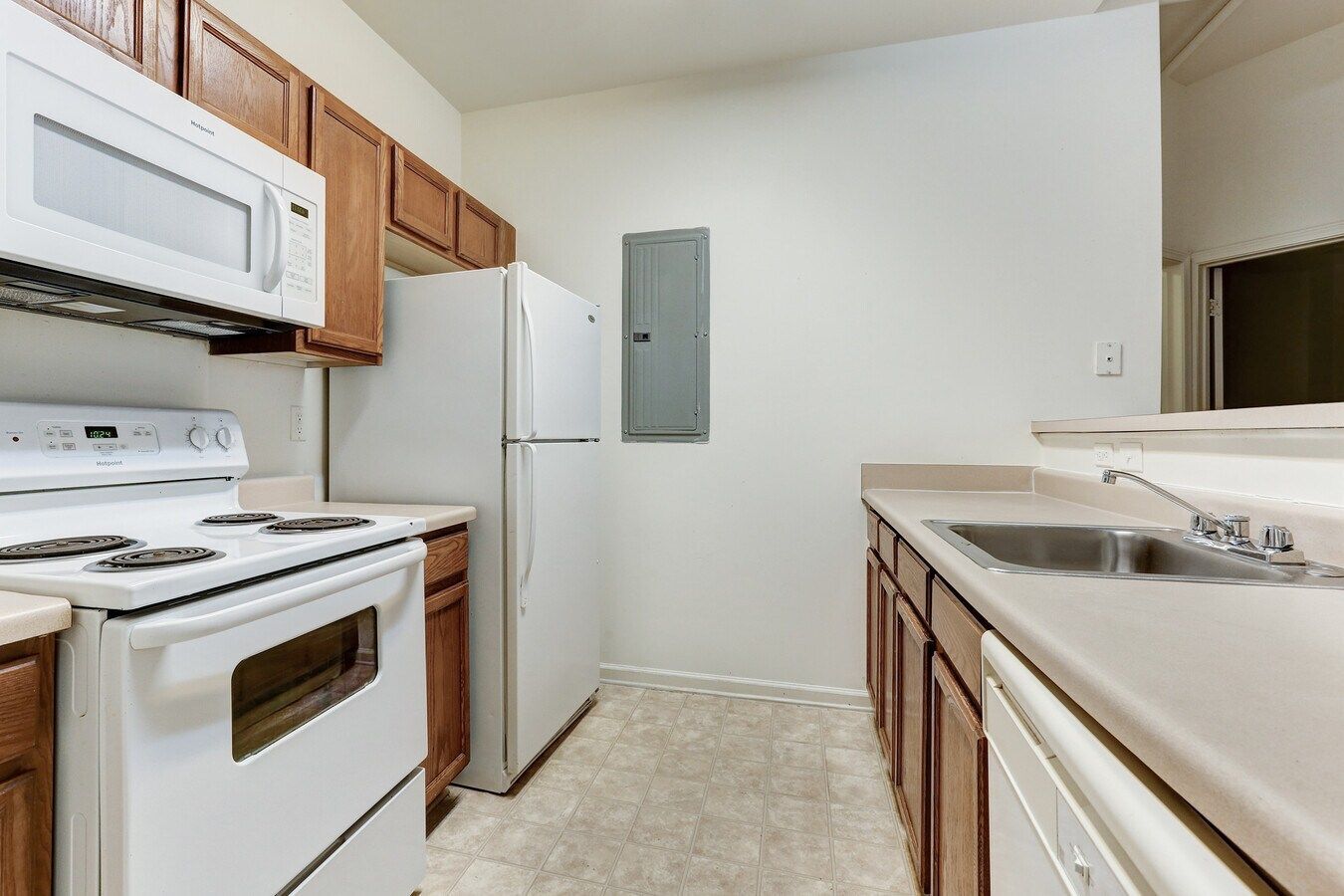 Kitchen with white appliances and wood cabinets.