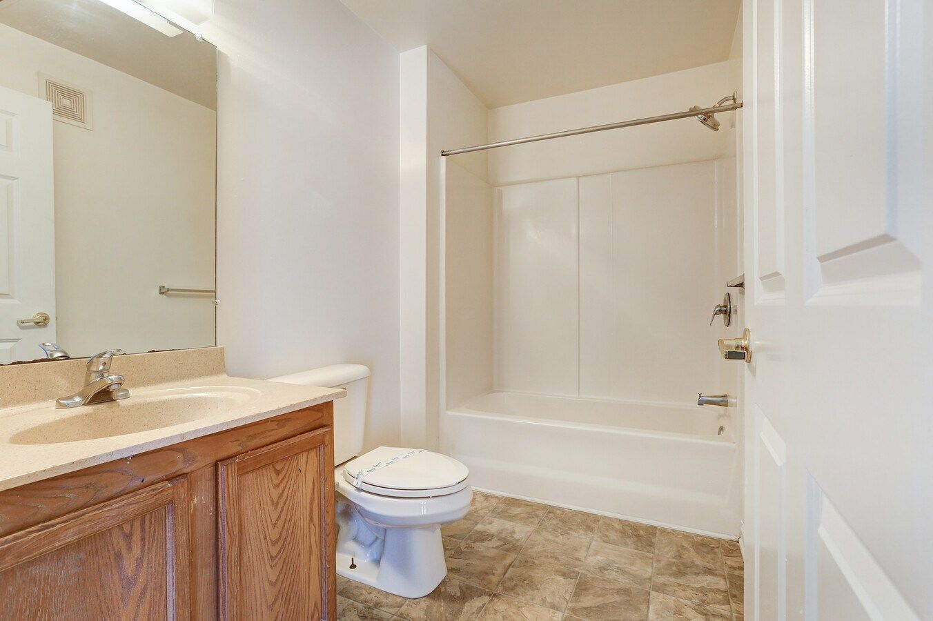 Bathroom with a vanity, toilet, and a shower/tub combo.