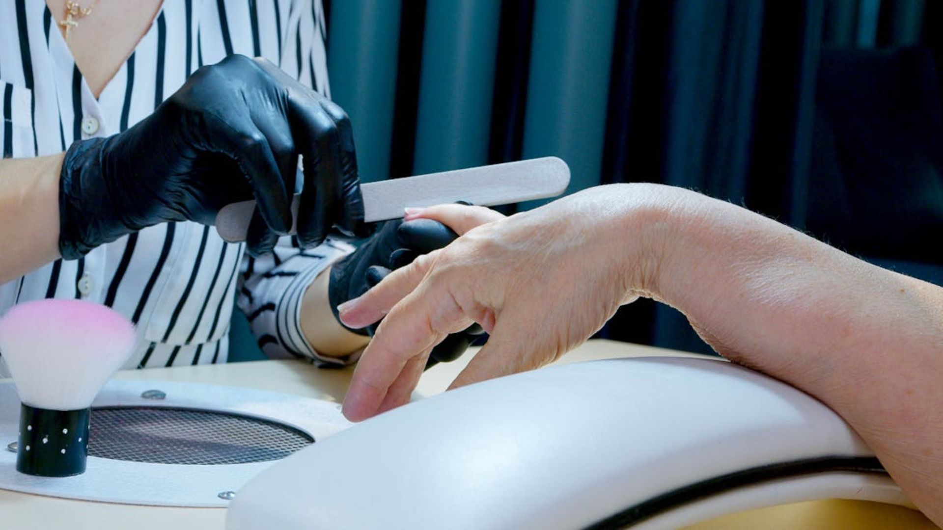 Una mujer se está haciendo las uñas en un salón de uñas.