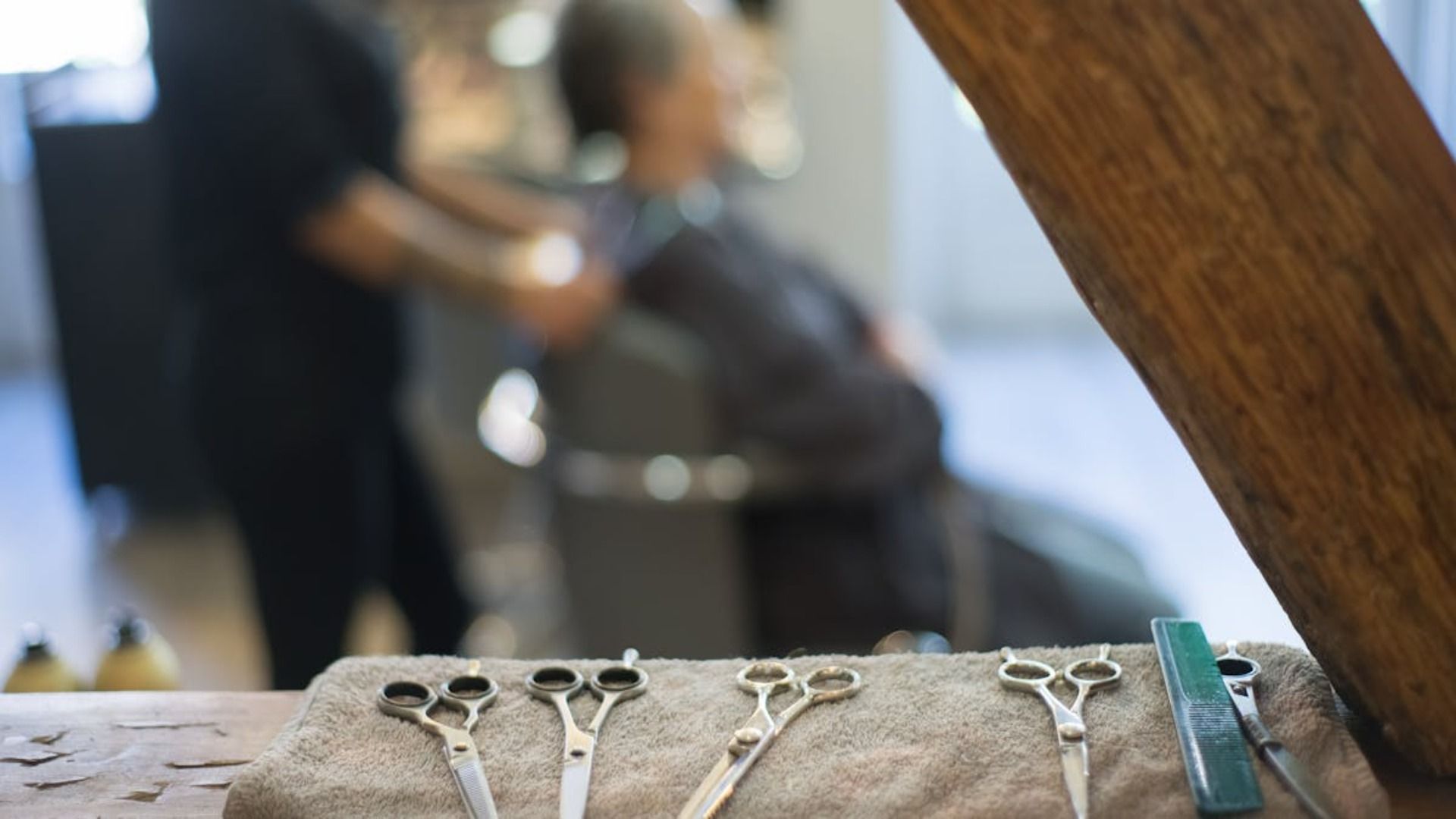 Una fila de tijeras colocadas encima de una toalla sobre una mesa.