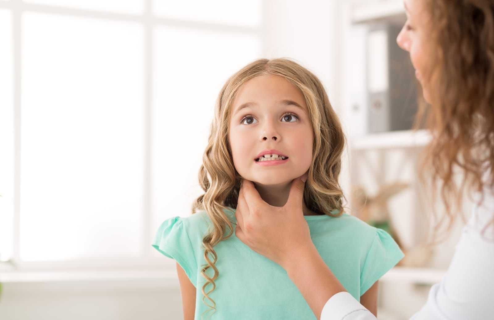 female-doctor-examining-girl-tonsils