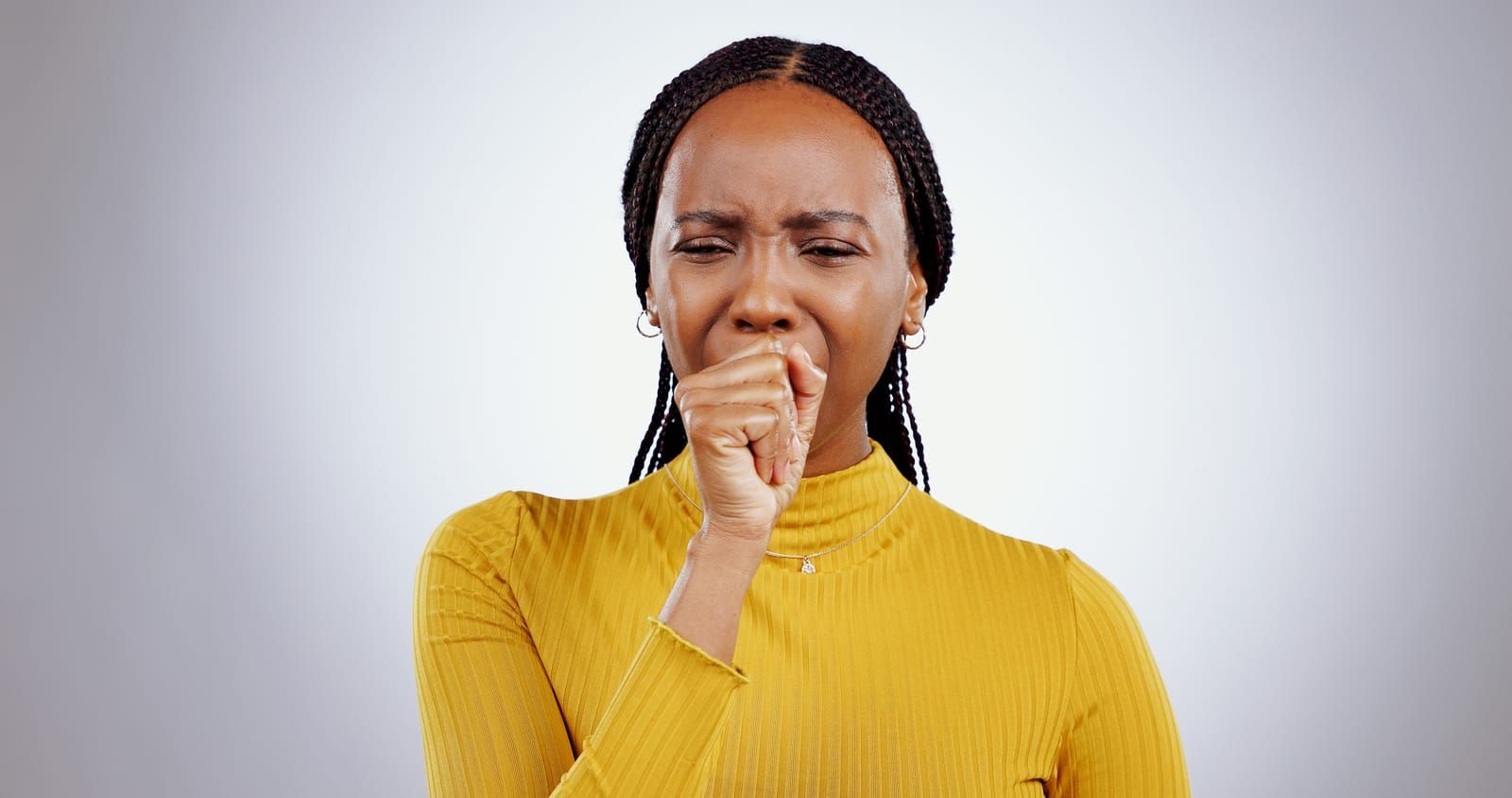 Photo of a woman coughing due to postnasal drip