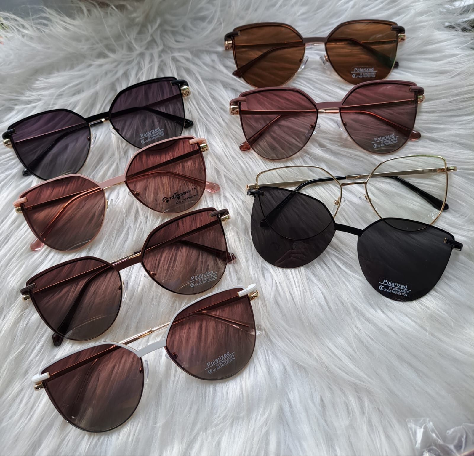 Unas gafas de sol en distintos tonos de marrón y rosa se muestran sobre una superficie blanca y esponjosa.