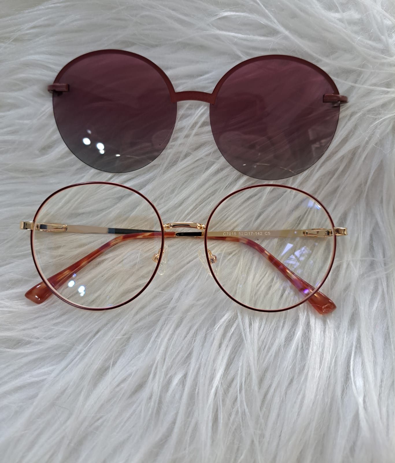 Dos pares de gafas de montura redonda, una tintada en granate y la otra transparente