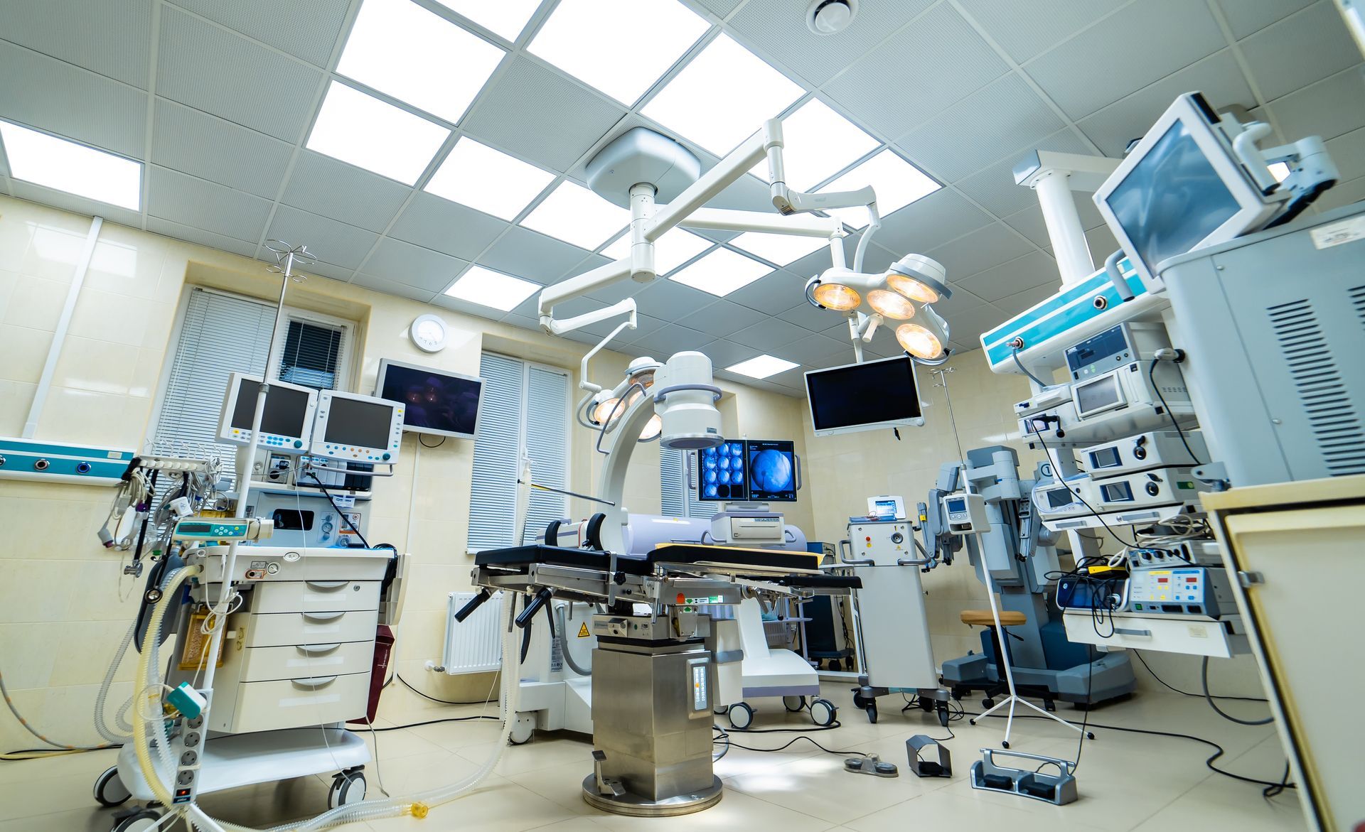 An empty operating room in a hospital with lots of medical equipment.