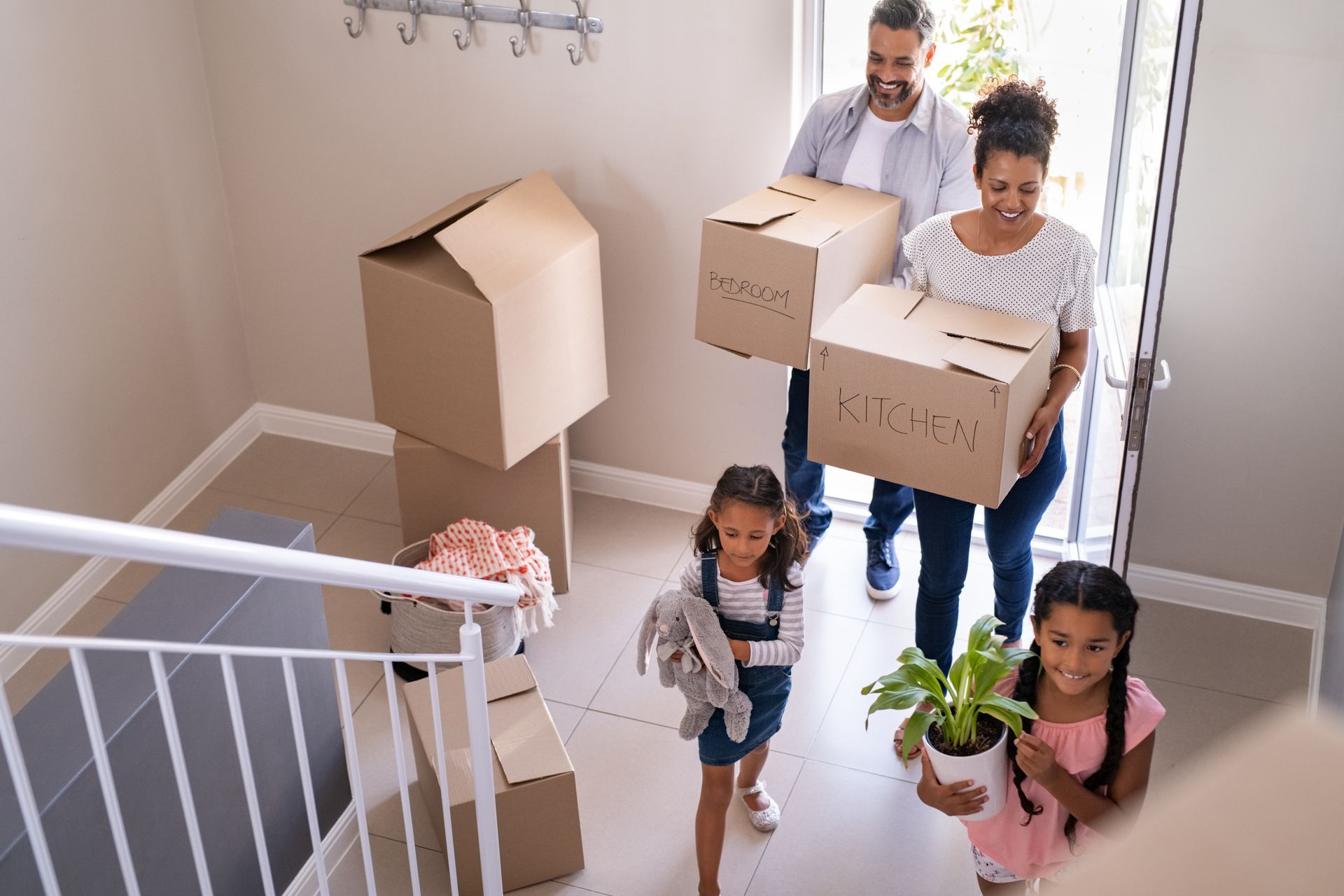 A family is carrying boxes into their new home.