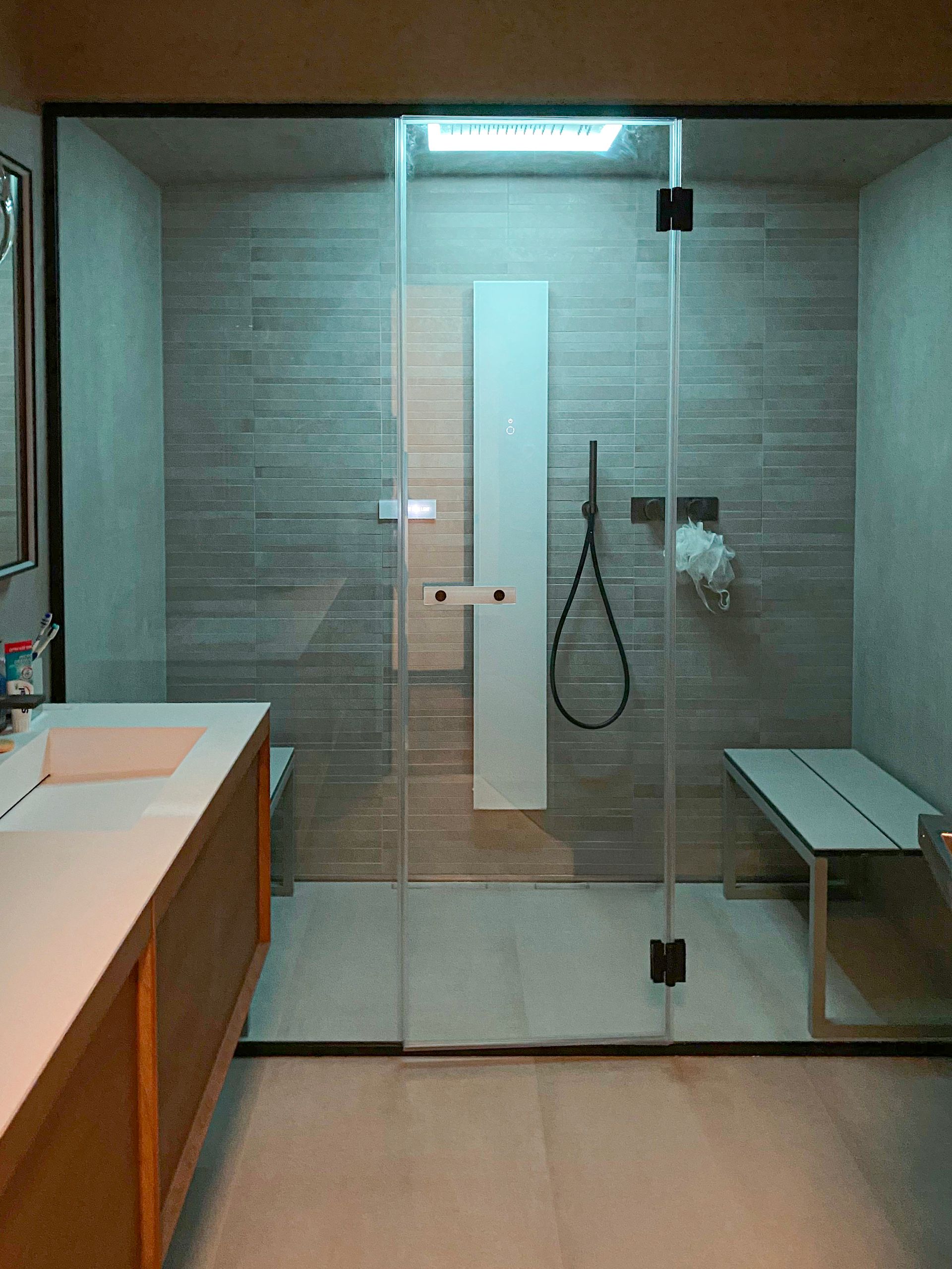 A bathroom with a walk in shower and a sink