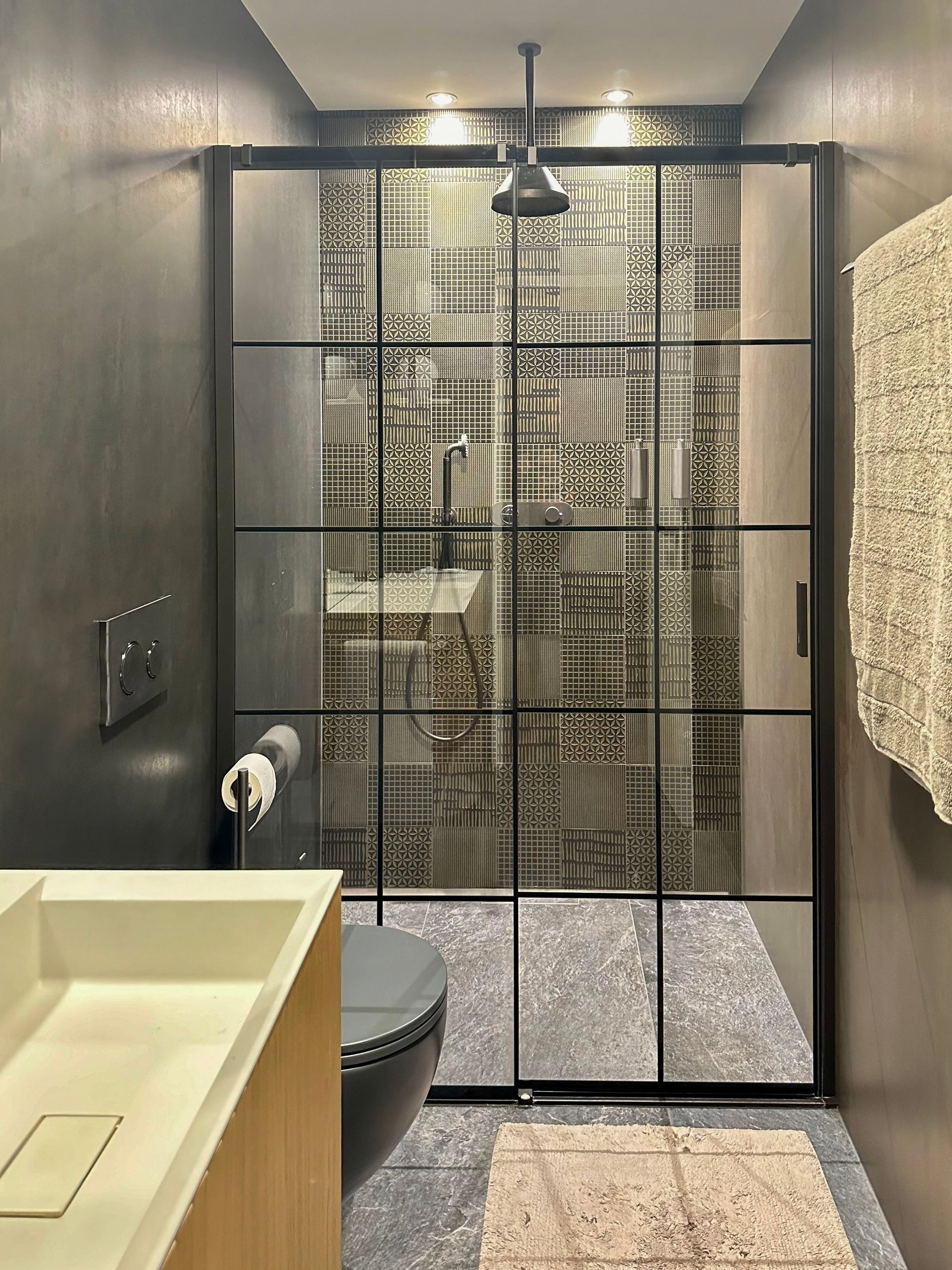 A bathroom with a sliding glass shower door