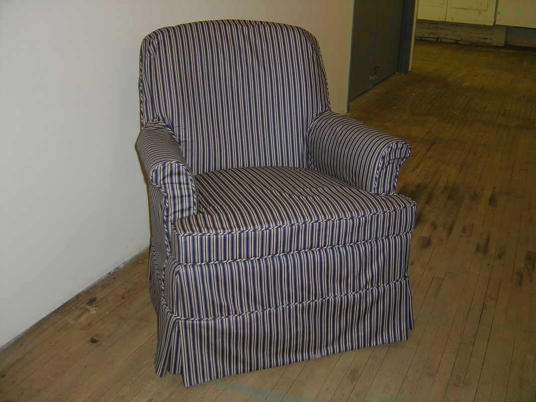 A black and white striped chair is sitting on a wooden floor.
