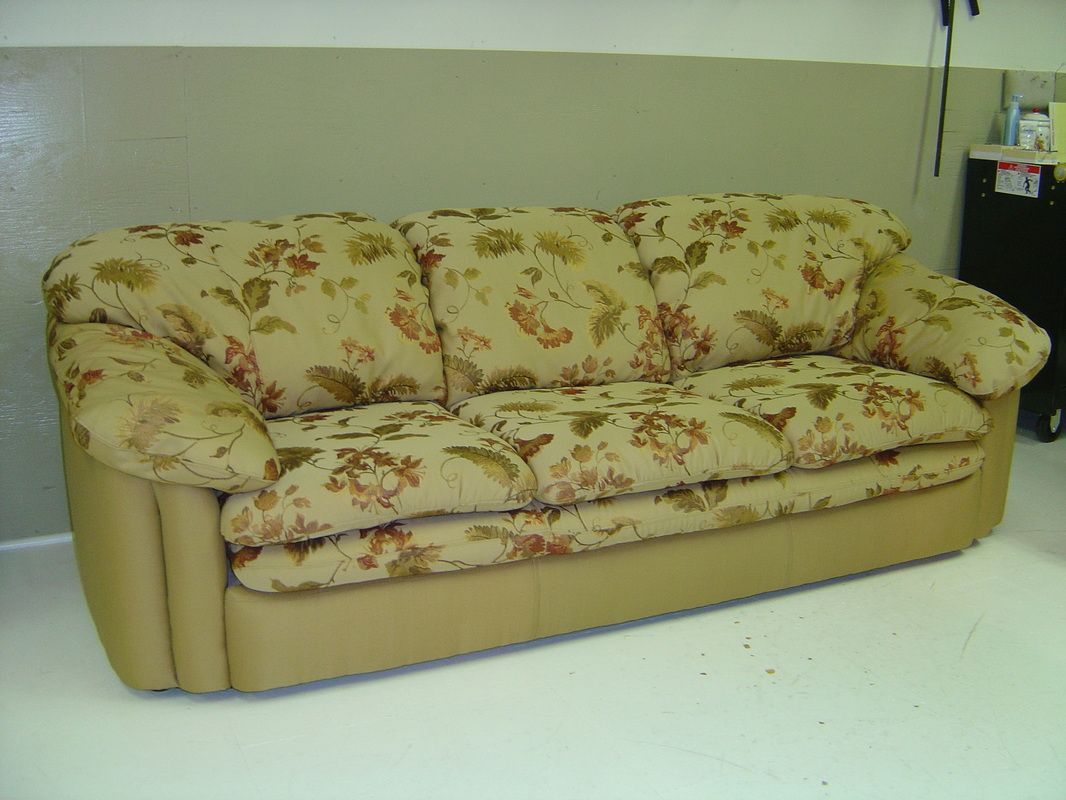 A floral couch is sitting on a white floor