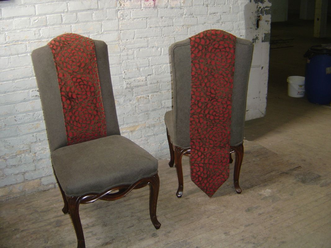 Two chairs are sitting next to each other in front of a white brick wall.