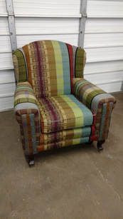 A colorful striped chair is sitting in front of a garage door.