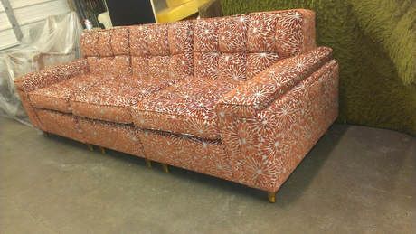 A couch with a pattern on it is sitting on the floor in a room.