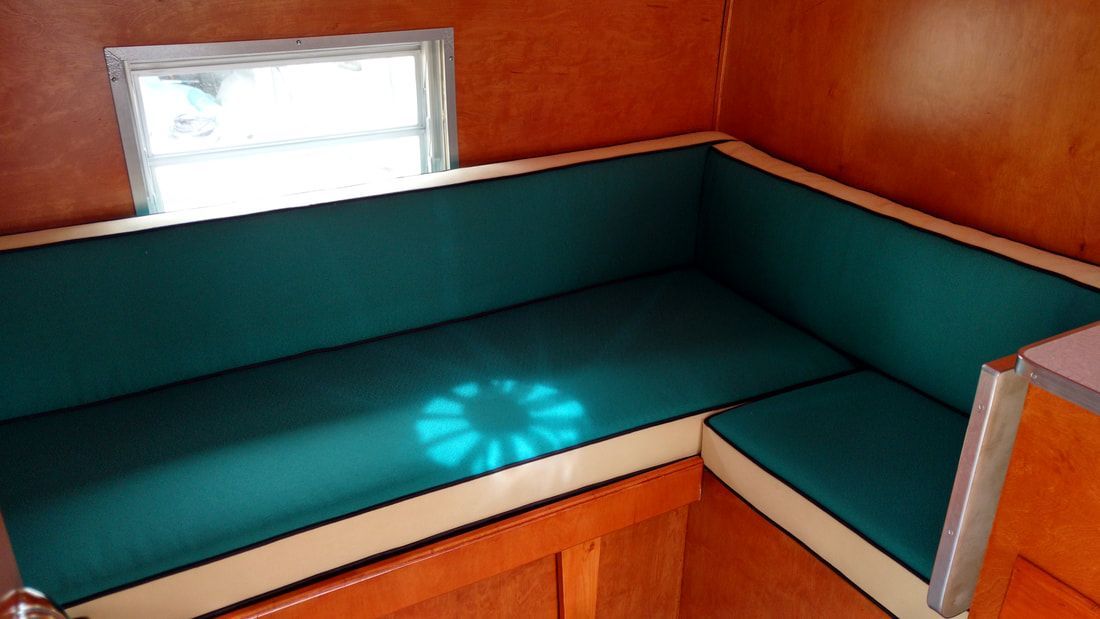 A couch with a blue cushion and a window in the background