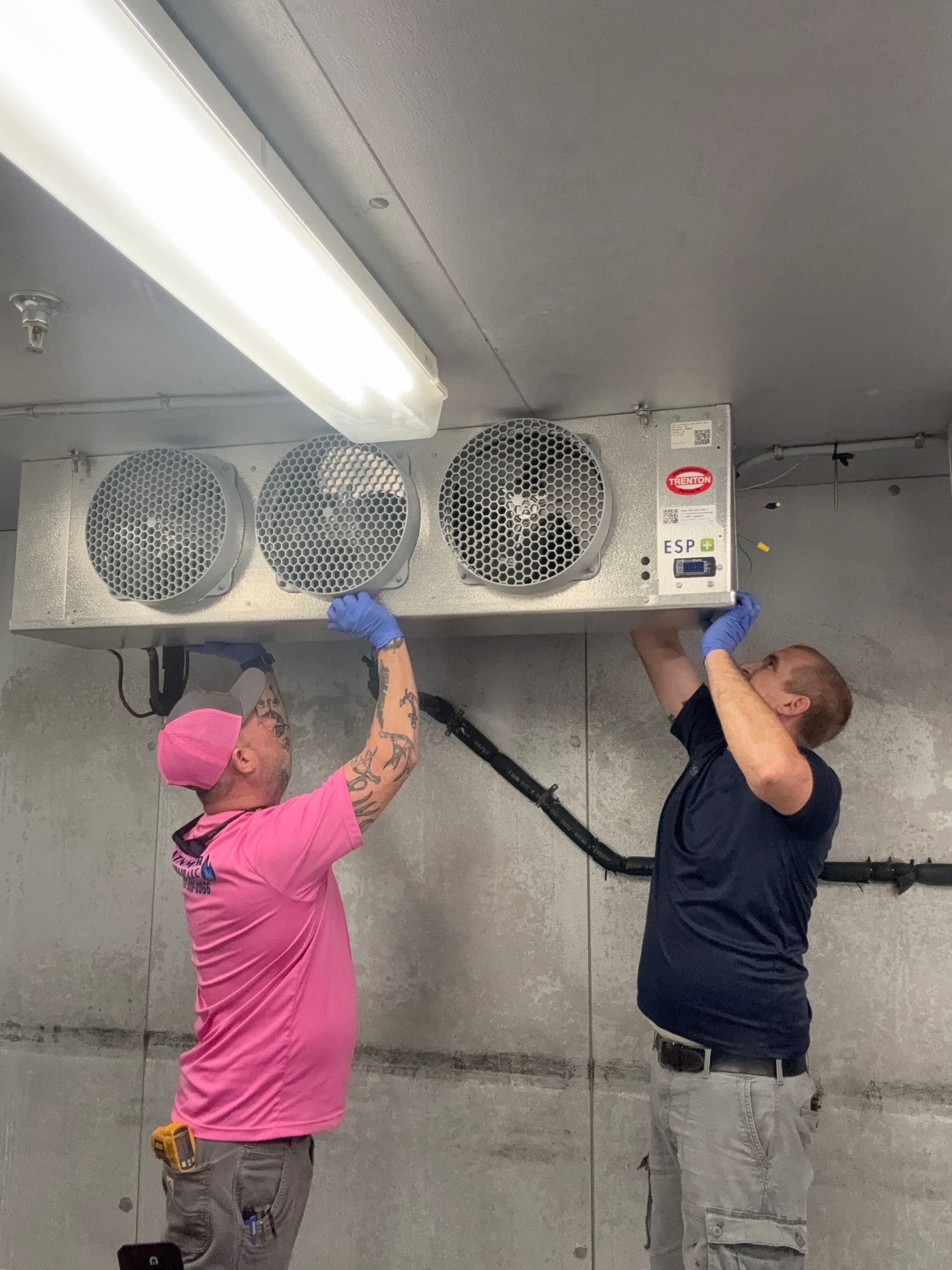 HVAC technician using pressure gauges on an air conditioning unit.