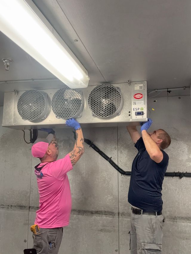 HVAC technician using pressure gauges on an air conditioning unit.