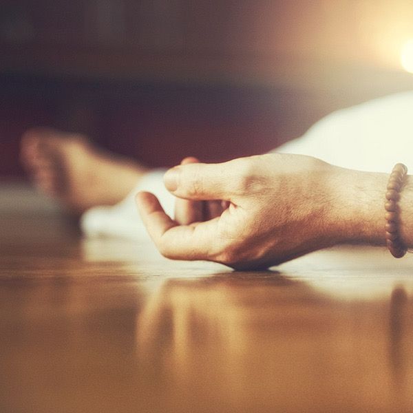 A person laying on the floor with their hand on the floor.