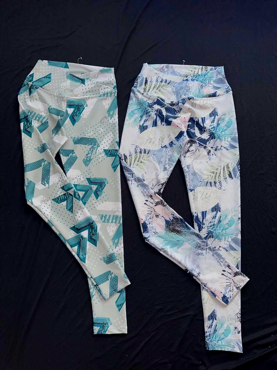 Dos pares de leggings estampados. Uno morado y negro, el otro naranja, marrón y azul.