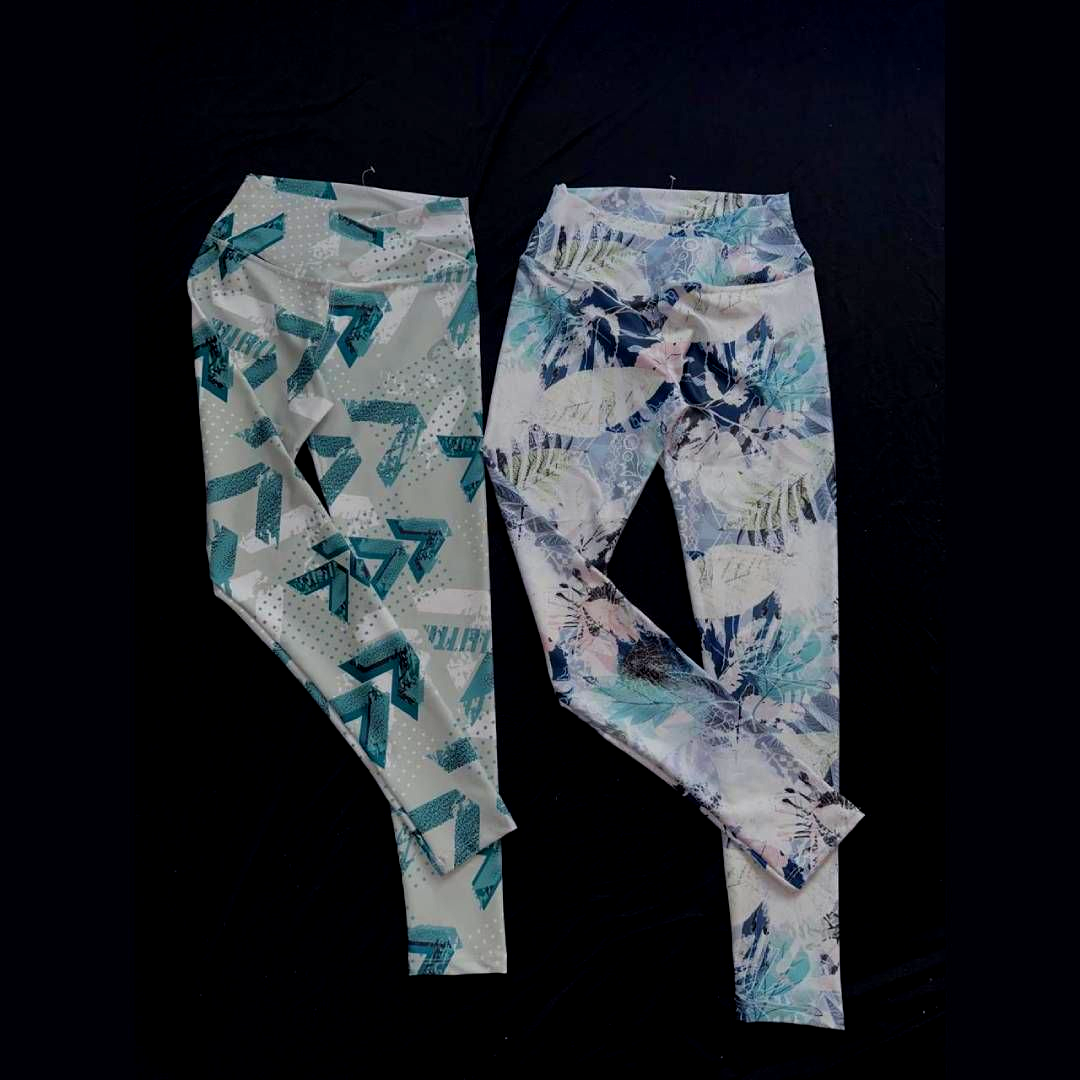 Dos pares de leggings estampados sobre una superficie negra.