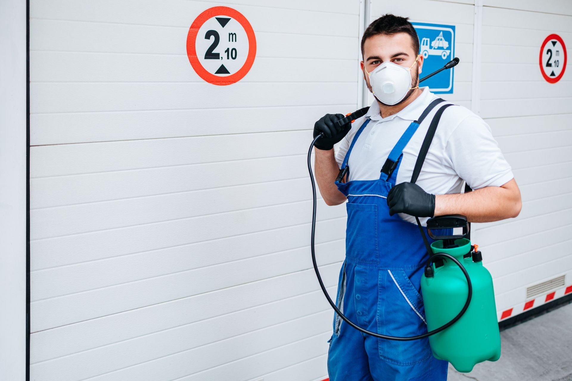 Local Animal Control Services worker in blue overalls holding pest control equipment.