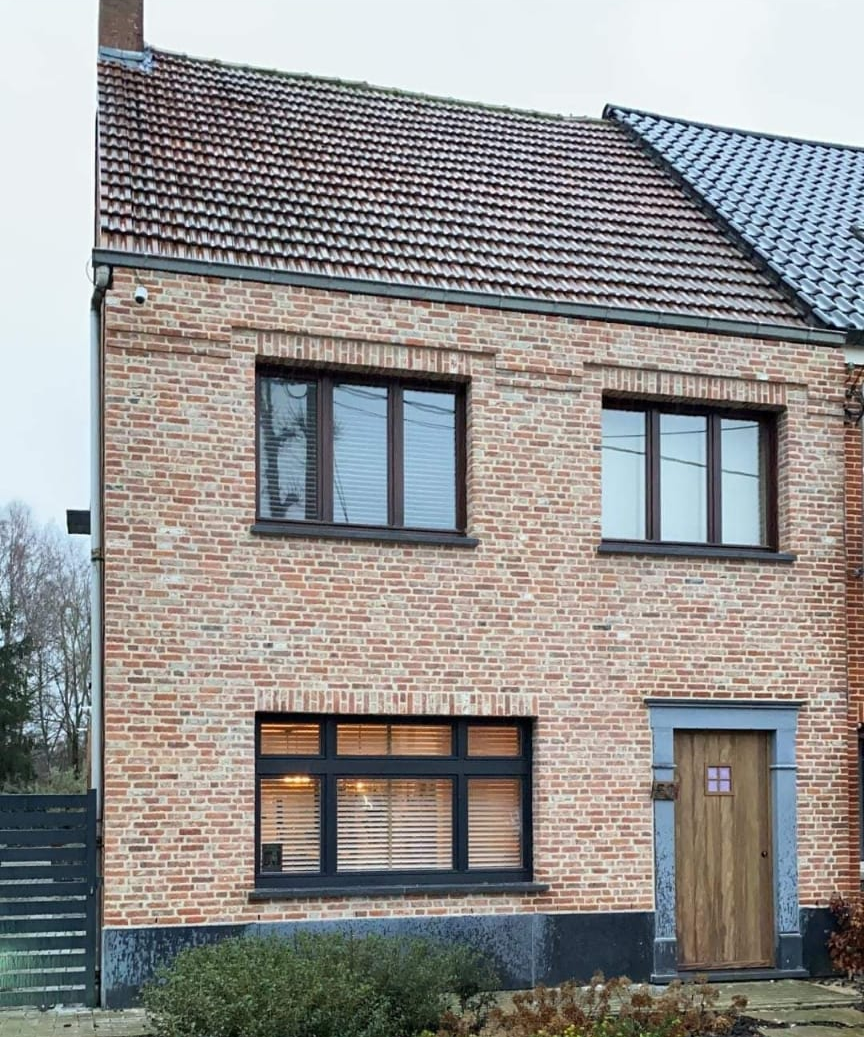 Een groot bakstenen huis met een trap ernaartoe