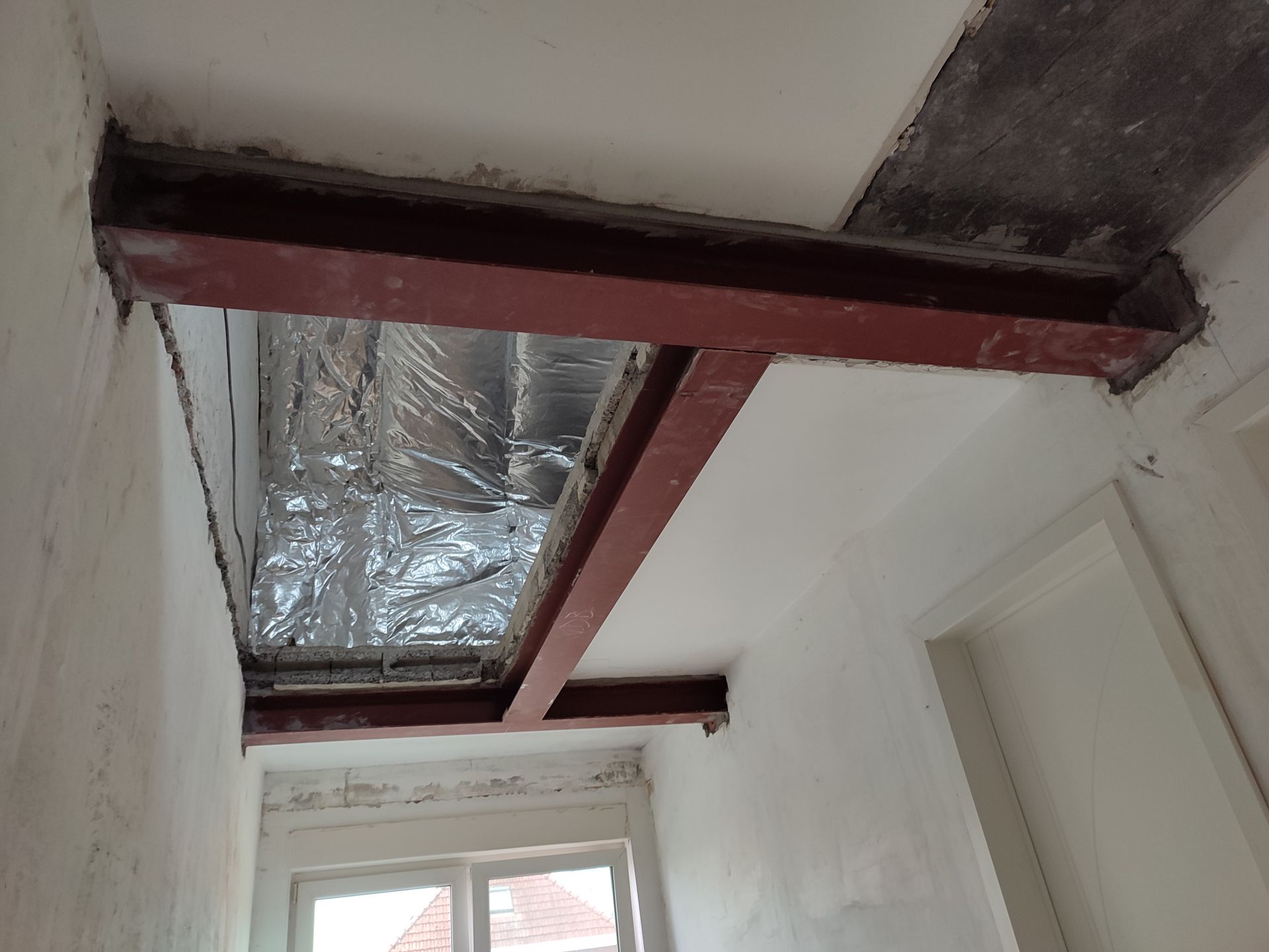 Een gang met een metalen balk die door het plafond gaat.