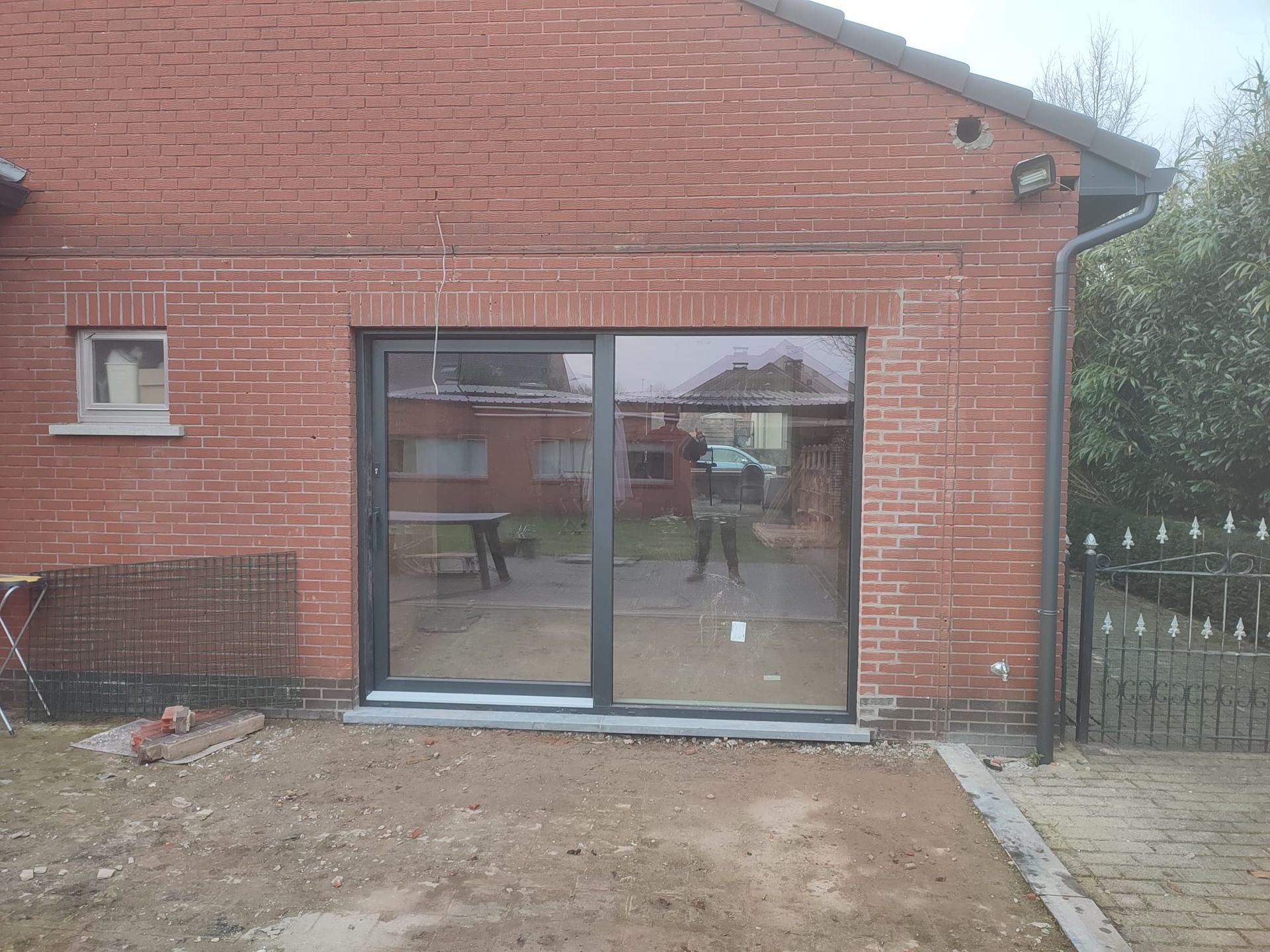 Een bakstenen gebouw met een glazen schuifdeur in de achtertuin.