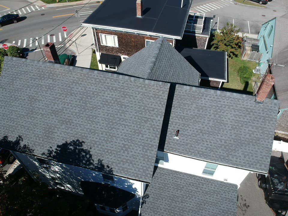 An aerial view of a house with a gray roof