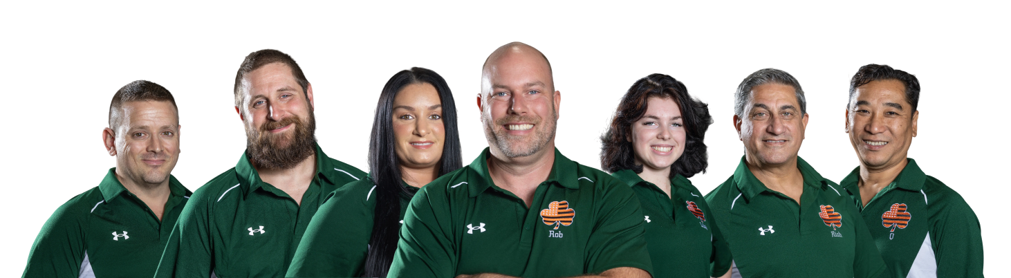 Group of people in green shirts, smiling. White background.